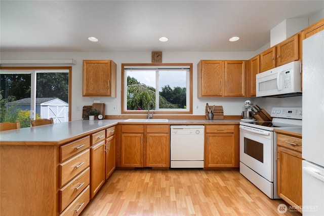 3401 F Ave, Anacortes, WA 98221 - kitchen with white appliances, a peninsula, light wood-style floors, recessed lighting, and brown cabinetry