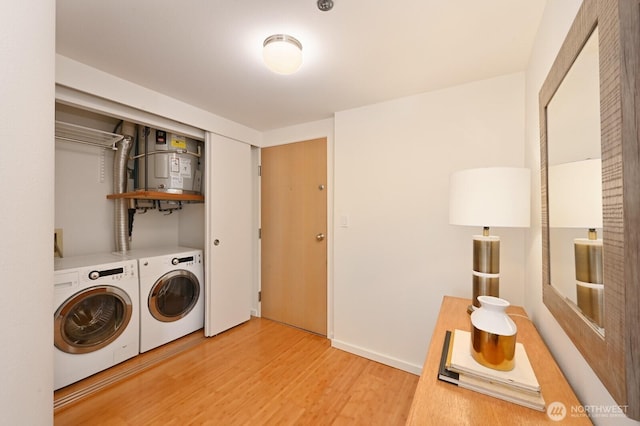 121 Vine St Unit 703, Seattle, WA 98121 - laundry room with washing machine and clothes dryer, light wood finished floors, and strapped water heater