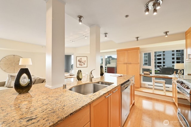 121 Vine St Unit 703, Seattle, WA 98121 - kitchen featuring appliances with stainless steel finishes, open floor plan, light stone countertops, rail lighting, and light wood-style floors