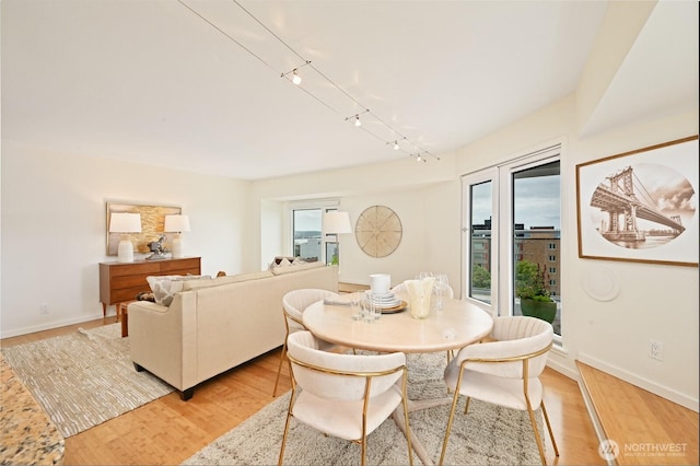 121 Vine St Unit 703, Seattle, WA 98121 - dining area featuring light wood finished floors and rail lighting