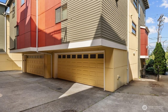 7747 Sand Point Way NE Unit A, Seattle, WA 98115 - view of building exterior with a garage and driveway