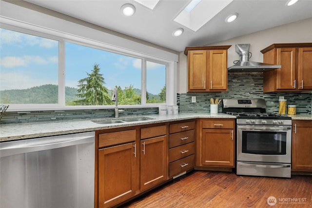 12712 232nd Ave E, Buckley, WA 98321 - kitchen with stainless steel appliances, wall chimney exhaust hood, a skylight, backsplash, and recessed lighting