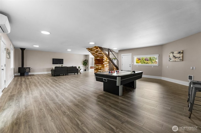 12712 232nd Ave E, Buckley, WA 98321 - playroom featuring a wood stove, an AC wall unit, dark wood finished floors, and recessed lighting