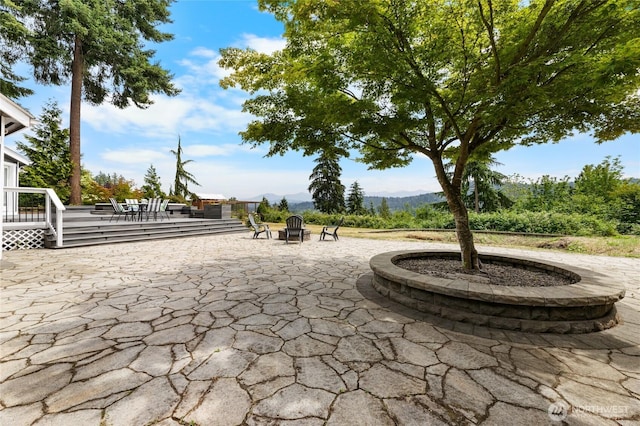 12712 232nd Ave E, Buckley, WA 98321 - view of patio / terrace with an outdoor fire pit and a deck with mountain view