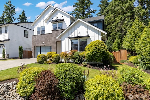 8784 NE Winslow Grove Ct, Bainbridge Island, WA 98110 - view of front of home featuring board and batten siding, an attached garage, driveway, and brick siding