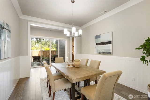 8784 NE Winslow Grove Ct, Bainbridge Island, WA 98110 - dining space featuring wainscoting, dark wood-style flooring, a chandelier, and crown molding