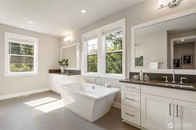 8784 NE Winslow Grove Ct, Bainbridge Island, WA 98110 - bathroom featuring plenty of natural light, two vanities, a freestanding tub, and recessed lighting