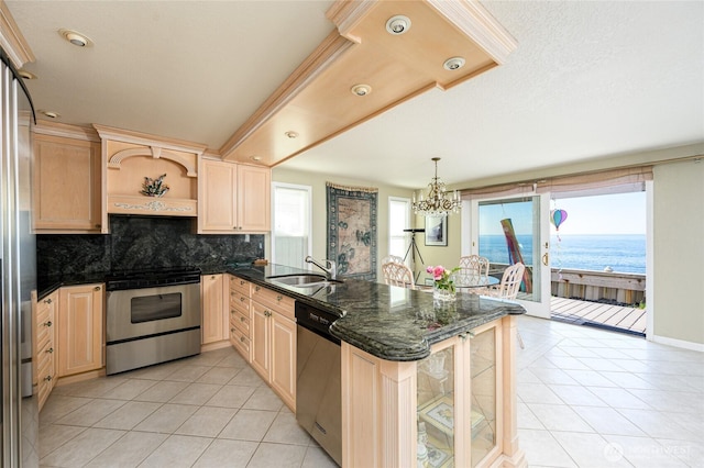 1523 N Whitecap Ln, Oak Harbor, WA 98277 - kitchen with appliances with stainless steel finishes, light brown cabinets, a peninsula, light tile patterned floors, and decorative backsplash