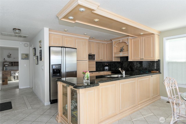 1523 N Whitecap Ln, Oak Harbor, WA 98277 - kitchen with appliances with stainless steel finishes, light brown cabinetry, light tile patterned floors, backsplash, and a peninsula