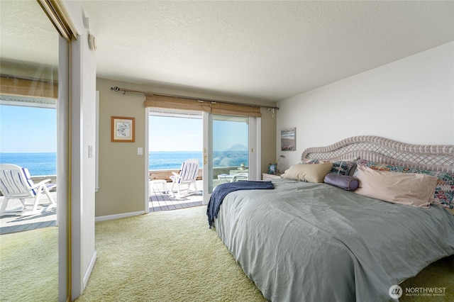 1523 N Whitecap Ln, Oak Harbor, WA 98277 - bedroom featuring carpet, access to exterior, a water view, and a textured ceiling