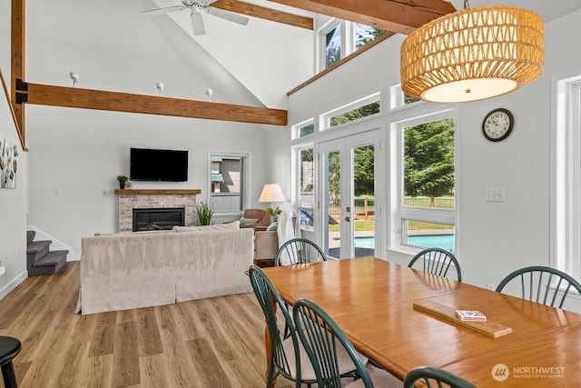 491 Pebble Beach Dr, Cle Elum, WA 98922 - dining room with high vaulted ceiling, a glass covered fireplace, ceiling fan, light wood finished floors, and stairs