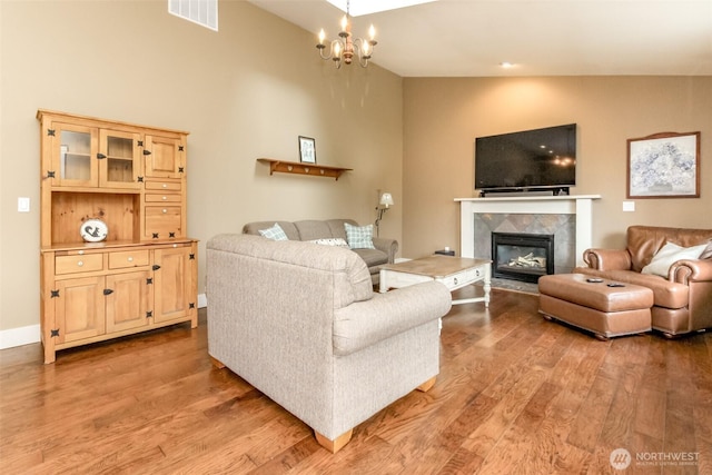 5117 77th St E, Tacoma, WA 98443 - living area with light wood-style flooring, a tile fireplace, and a chandelier