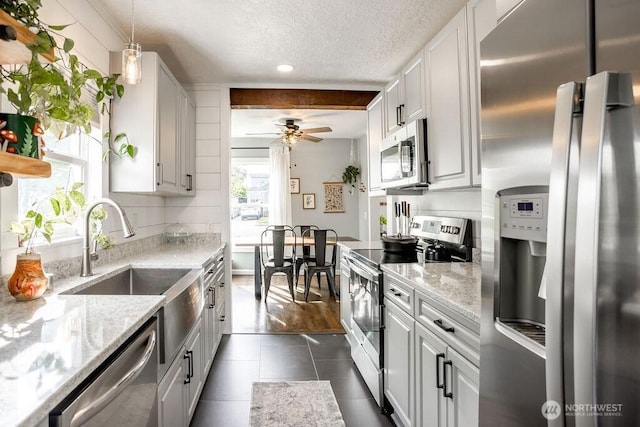 526 20th Ave, Longview, WA 98632 - kitchen featuring appliances with stainless steel finishes, a textured ceiling, dark tile patterned floors, a ceiling fan, and light stone counters