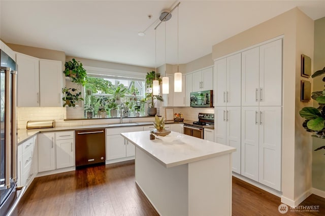 3116 164th St SW Unit 806, Lynnwood, WA 98087 - kitchen with appliances with stainless steel finishes, white cabinetry, tasteful backsplash, dark wood-style flooring, and pendant lighting