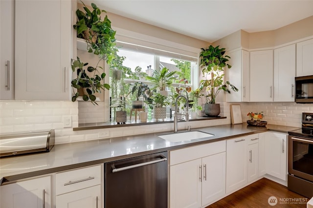 3116 164th St SW Unit 806, Lynnwood, WA 98087 - kitchen featuring stainless steel appliances, white cabinets, backsplash, and dark wood-style floors
