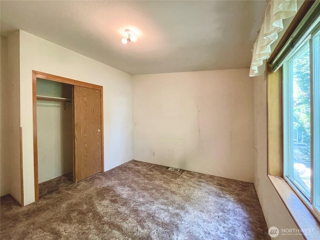 115 4th Ave SE, Soap Lake, WA 98851 - unfurnished bedroom featuring multiple windows, carpet flooring, and a closet