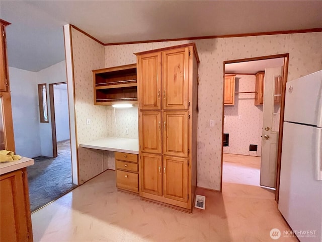 115 4th Ave SE, Soap Lake, WA 98851 - kitchen featuring freestanding refrigerator, wallpapered walls, vaulted ceiling, built in study area, and light countertops