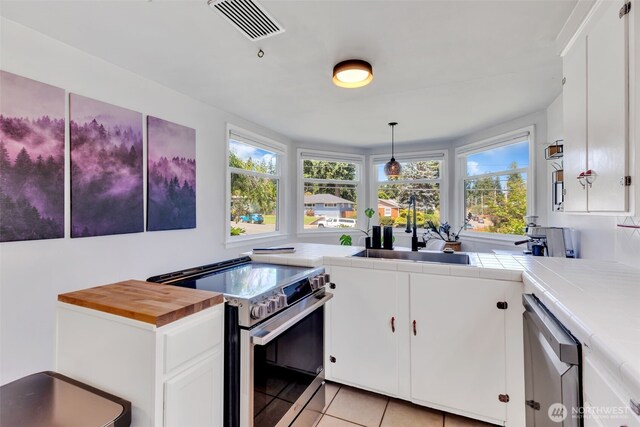 804 Electron Way, Fircrest, WA 98466 - kitchen with appliances with stainless steel finishes, plenty of natural light, light tile patterned floors, and tile countertops