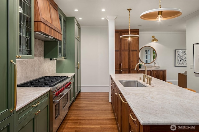 740 22nd Ave E, Seattle, WA 98112 - kitchen featuring green cabinetry, range with two ovens, light countertops, a kitchen island with sink, and ornamental molding