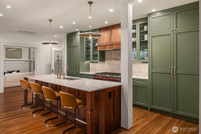 740 22nd Ave E, Seattle, WA 98112 - kitchen with green cabinets, decorative backsplash, dark wood finished floors, a breakfast bar, and an island with sink