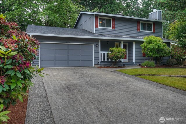 16420 92nd Avenue Ct E, Puyallup, WA 98375 - traditional home featuring a chimney, a porch, driveway, and an attached garage