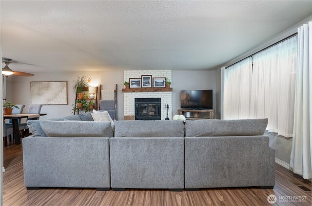 16420 92nd Avenue Ct E, Puyallup, WA 98375 - living room featuring wood finished floors, a fireplace, and a ceiling fan