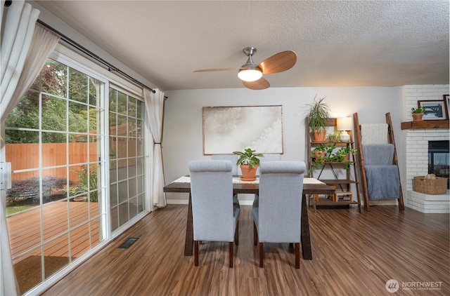 16420 92nd Avenue Ct E, Puyallup, WA 98375 - dining area with ceiling fan, wood finished floors, a fireplace, and a textured ceiling