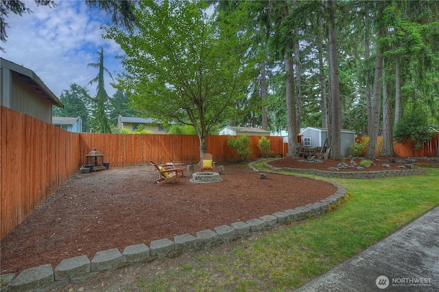 16420 92nd Avenue Ct E, Puyallup, WA 98375 - fenced backyard featuring a fire pit and a storage unit