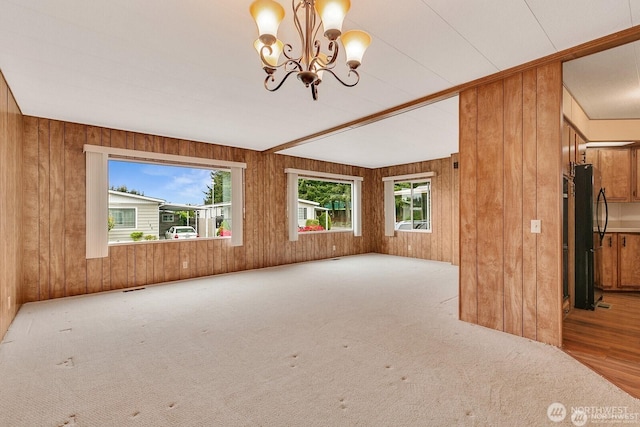 1415 84th St SE Unit 192, Everett, WA 98208 - unfurnished living room with wooden walls, carpet, and a chandelier