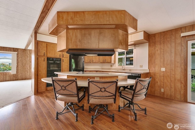 1415 84th St SE Unit 192, Everett, WA 98208 - kitchen with freestanding refrigerator, wooden walls, light wood finished floors, light countertops, and brown cabinetry
