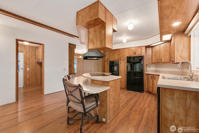1415 84th St SE Unit 192, Everett, WA 98208 - kitchen with black appliances, light wood finished floors, light countertops, brown cabinetry, and a kitchen breakfast bar
