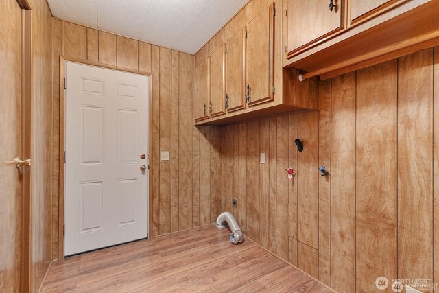 1415 84th St SE Unit 192, Everett, WA 98208 - laundry area featuring cabinet space, electric dryer hookup, wooden walls, and light wood-style floors