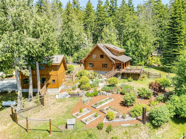 194 Protection Ridge Dr, Port Townsend, WA 98368 - rear view of house with a vegetable garden, log siding, a forest view, stairs, and board and batten siding