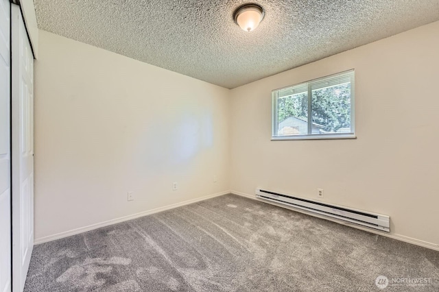 1700317009 16th Ave E, Spanaway, WA 98387 - carpeted spare room featuring a baseboard heating unit and a textured ceiling