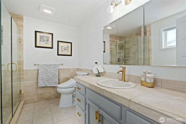 153 Swinomish Dr, La Conner, WA 98257 - bathroom featuring tile patterned flooring, vanity, tile walls, a shower stall, and a wainscoted wall
