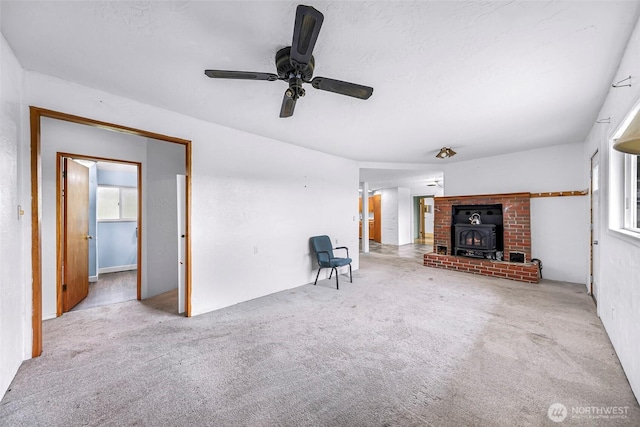 8739 F And S Grade Rd, Sedro Woolley, WA 98284 - unfurnished living room featuring a wood stove, carpet flooring, and a ceiling fan