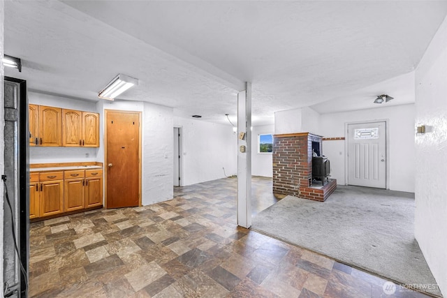 8739 F And S Grade Rd, Sedro Woolley, WA 98284 - unfurnished living room with a wood stove, healthy amount of natural light, and a textured ceiling