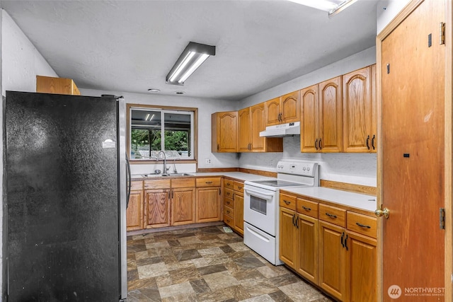 8739 F And S Grade Rd, Sedro Woolley, WA 98284 - kitchen featuring freestanding refrigerator, white electric range, under cabinet range hood, stone finish flooring, and light countertops