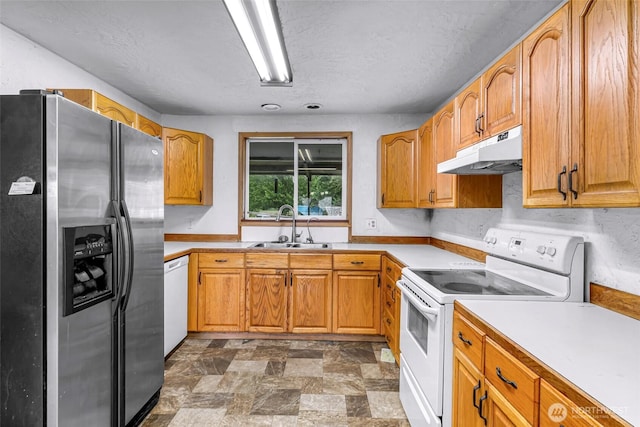 8739 F And S Grade Rd, Sedro Woolley, WA 98284 - kitchen featuring white appliances, under cabinet range hood, light countertops, stone finish floors, and brown cabinetry