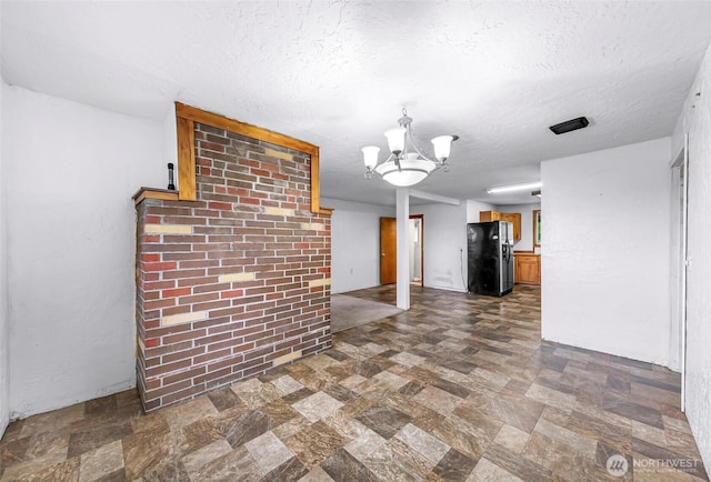 8739 F And S Grade Rd, Sedro Woolley, WA 98284 - unfurnished living room with a textured ceiling, a chandelier, and dark stone finish flooring