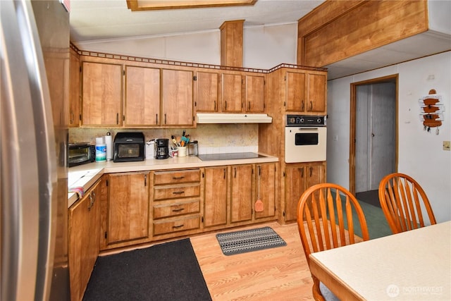 8031 Fir Tree Ln, Lake Stevens, WA 98258 - kitchen with oven, freestanding refrigerator, lofted ceiling, under cabinet range hood, and black electric cooktop