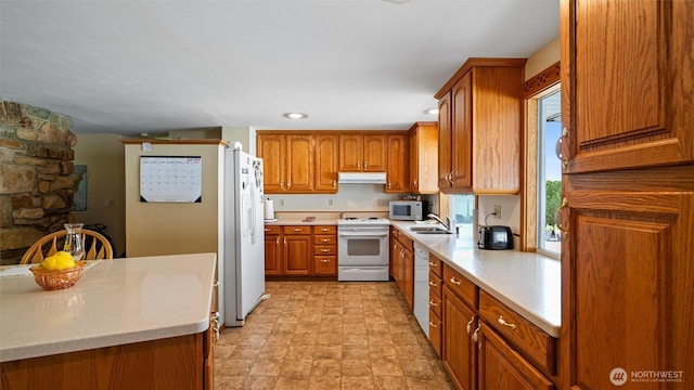 1314 S Division St, Walla Walla, WA 99362 - kitchen with white appliances, under cabinet range hood, brown cabinets, light countertops, and recessed lighting