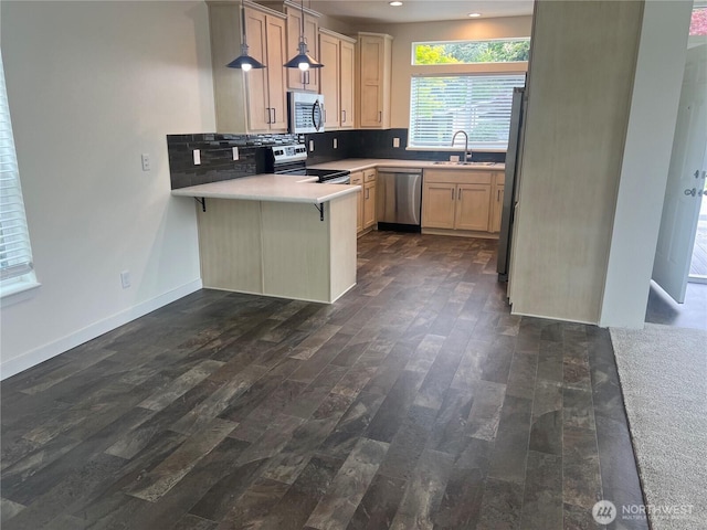 375 Union Ave SE Unit 97, Renton, WA 98059 - kitchen with stainless steel appliances, a peninsula, dark wood-style floors, backsplash, and a kitchen bar