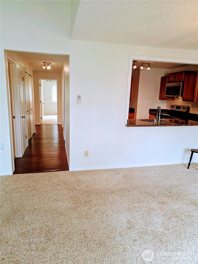 12840 SE 40th Ct Unit B12, Bellevue, WA 98006 - kitchen with appliances with stainless steel finishes, dark colored carpet, and a textured ceiling