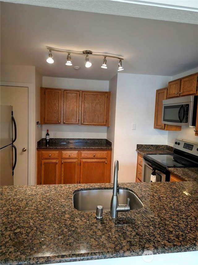 12840 SE 40th Ct Unit B12, Bellevue, WA 98006 - kitchen featuring stainless steel appliances, dark stone counters, and brown cabinetry
