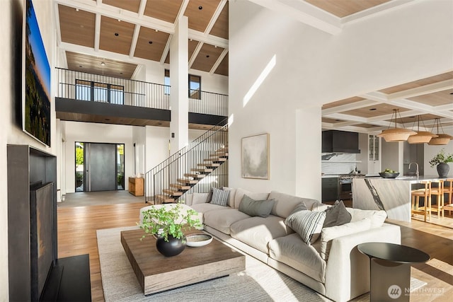 9001 NE 14th St, Clyde Hill, WA 98004 - living room with light wood-style floors, beam ceiling, stairs, coffered ceiling, and a high ceiling