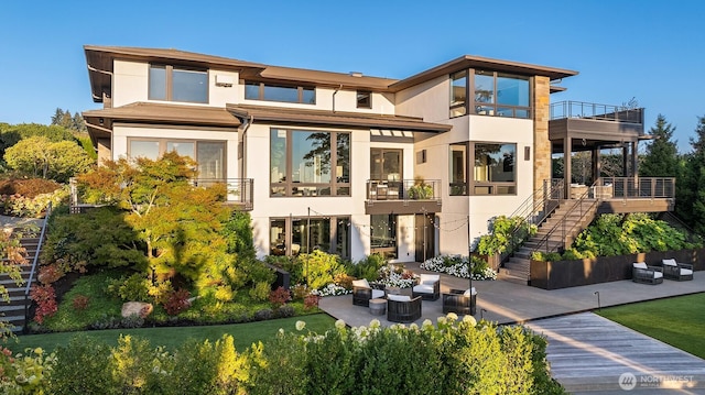 9001 NE 14th St, Clyde Hill, WA 98004 - back of property with stairway, outdoor lounge area, stucco siding, and a balcony