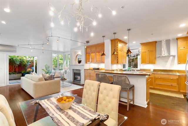719 2nd Ave W Unit 101, Seattle, WA 98119 - dining room featuring an AC wall unit, dark wood finished floors, recessed lighting, and a fireplace with flush hearth