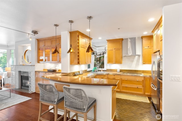 719 2nd Ave W Unit 101, Seattle, WA 98119 - kitchen with wall chimney exhaust hood, a peninsula, a breakfast bar area, black electric stovetop, and recessed lighting