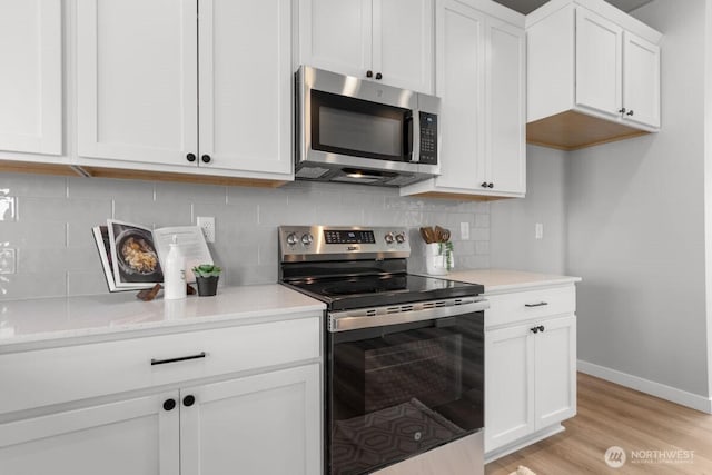 15726 40th Ave W Unit A4, Lynnwood, WA 98087 - kitchen featuring stainless steel appliances, white cabinetry, light wood-style floors, light countertops, and backsplash